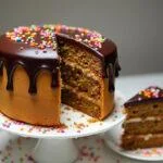 Bolo de cenoura humido e fofo decorado com cobertura de chocolate, perfeito para servir.