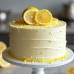 Bolo de limão úmido finalizado, decorado com fatias de limão, perfeito para servir.
