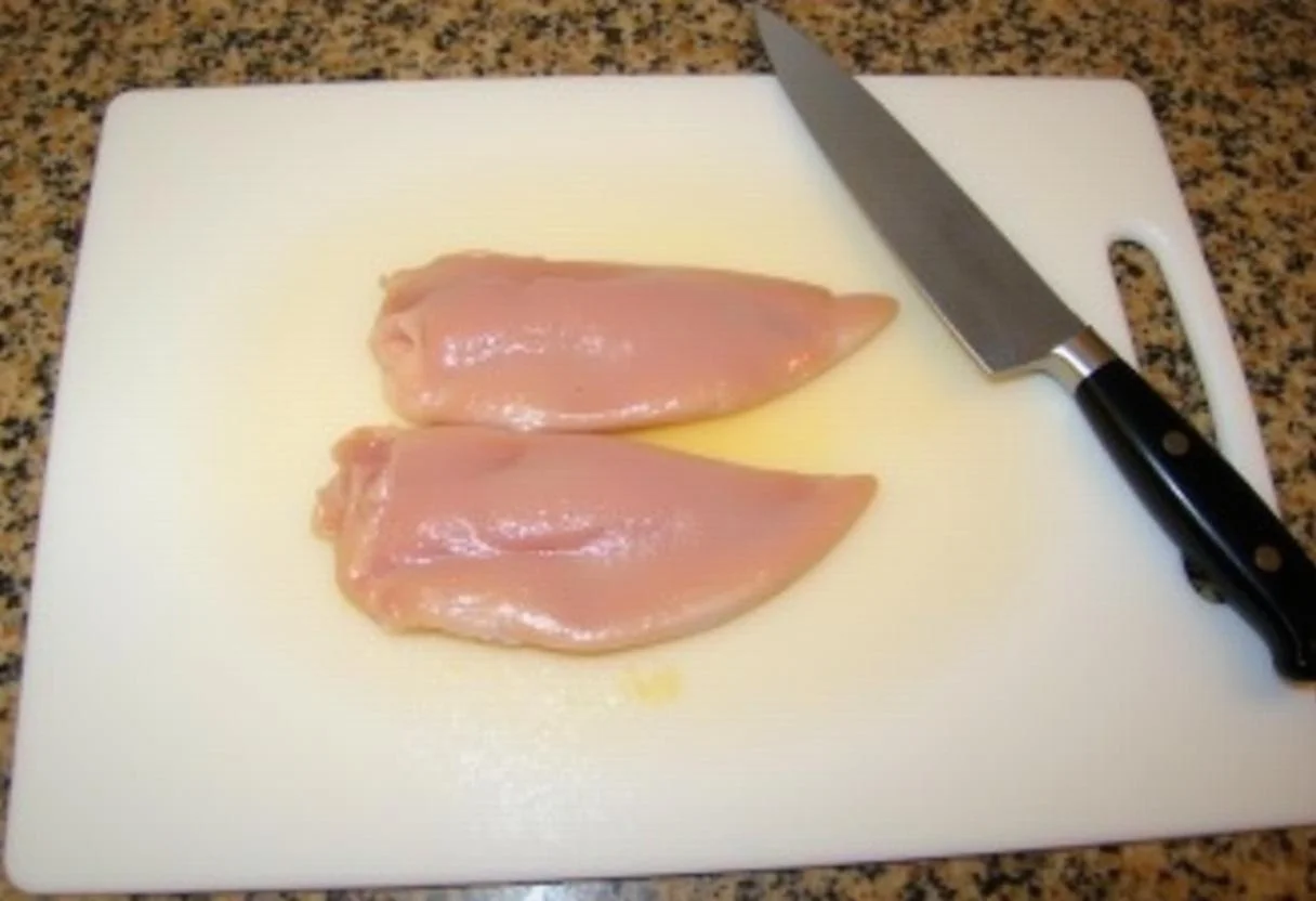 Peito de frango recheado preparado no tabuleiro de corte.